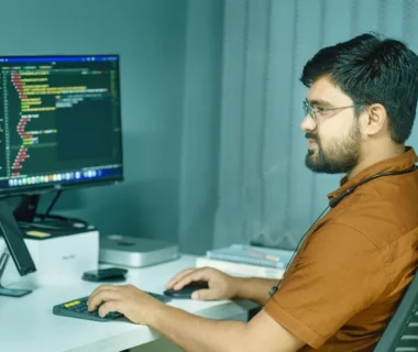a man sitting at a desk using a computer