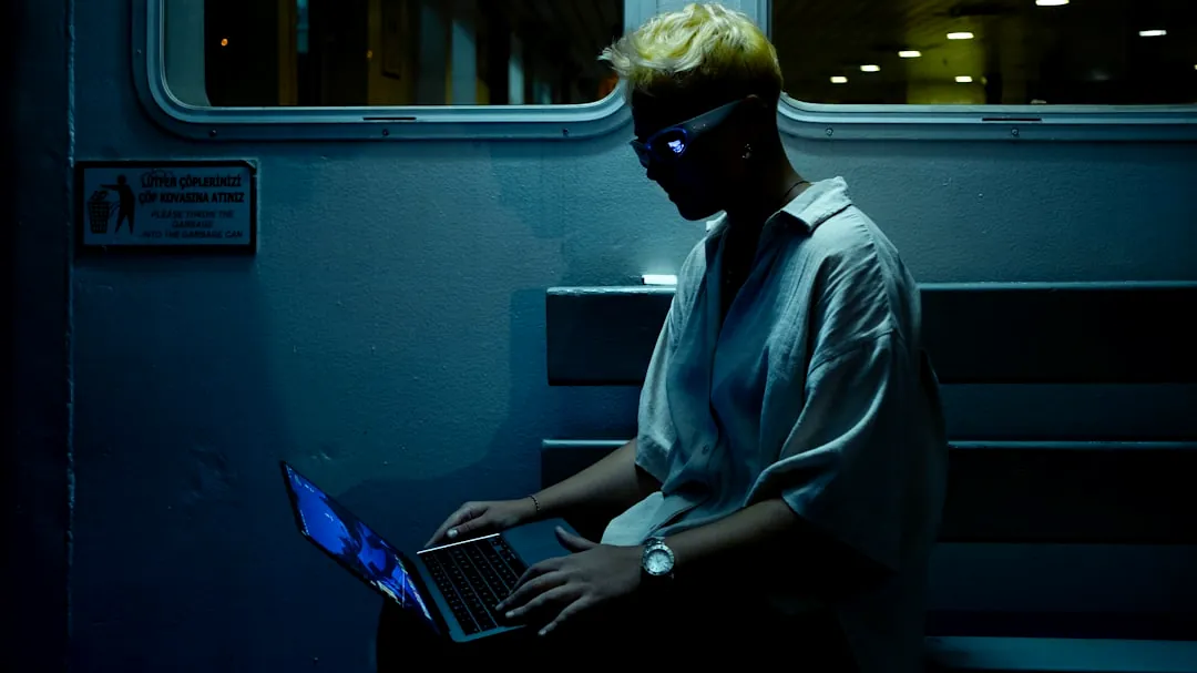 A man sitting on a train using a laptop computer