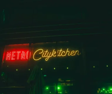 A neon sign is lit up on the side of a building