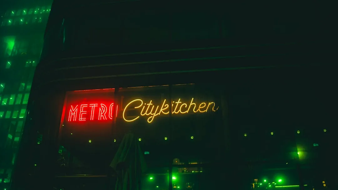 A neon sign is lit up on the side of a building