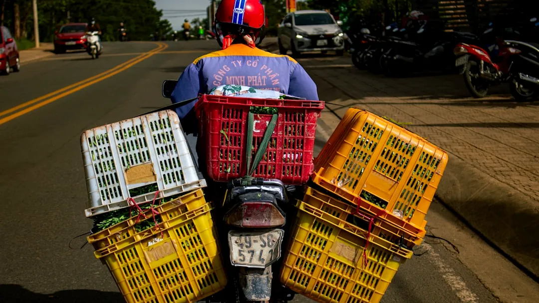 A person riding a motorcycle with baskets on the back of it
