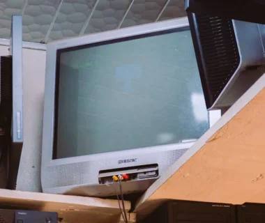 A room with two televisions and a keyboard