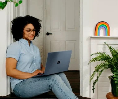 a woman sitting on the floor using a laptop