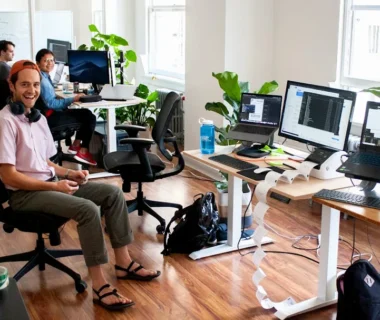 man in blue dress shirt sitting on black office rolling chair