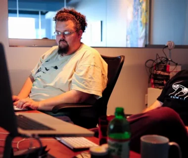 man in white crew neck t-shirt sitting on brown chair