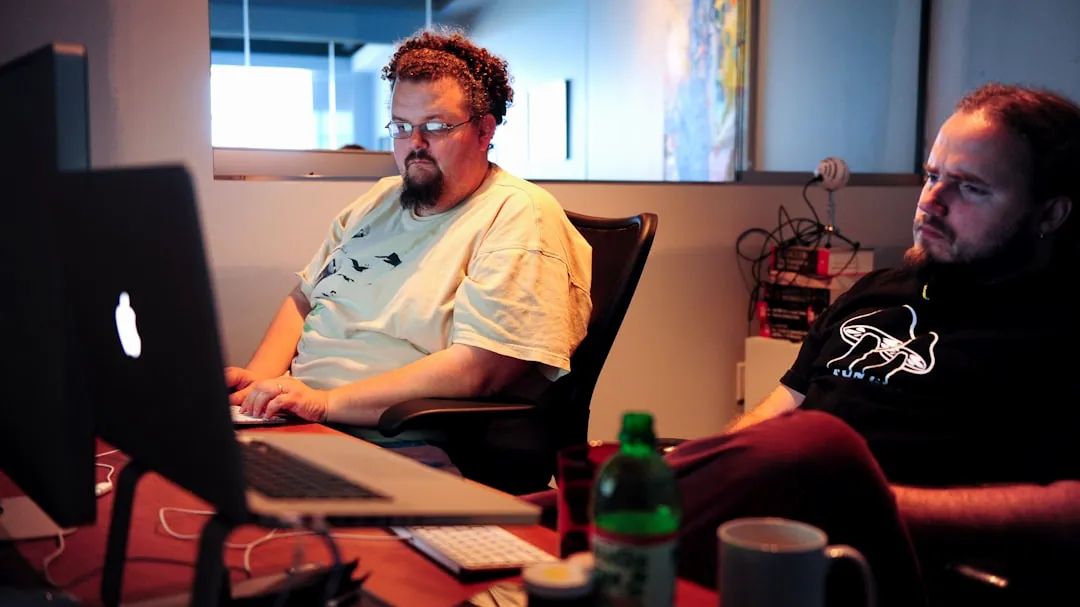 man in white crew neck t-shirt sitting on brown chair