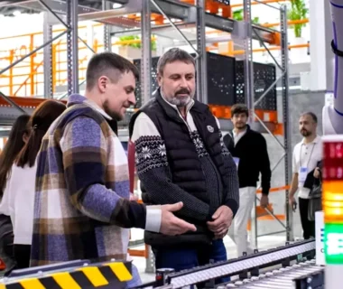 Men observe automated conveyor belt system in warehouse
