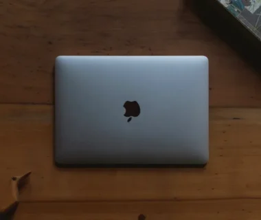 silver MacBook on brown wooden table