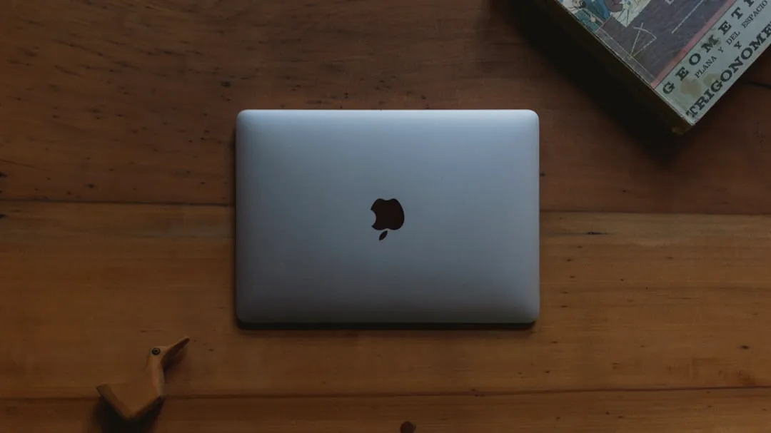silver MacBook on brown wooden table