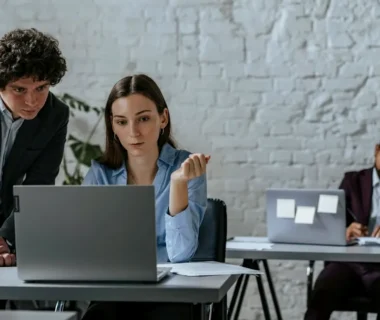 Two colleagues collaborating on a laptop in office.