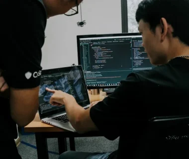 two men working on computers in an office