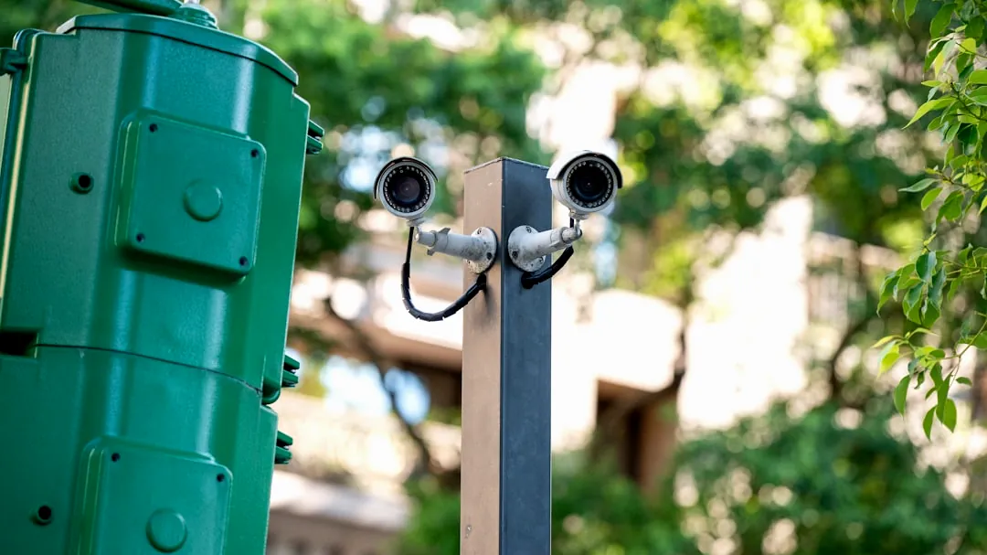Two security cameras mounted on a pole.