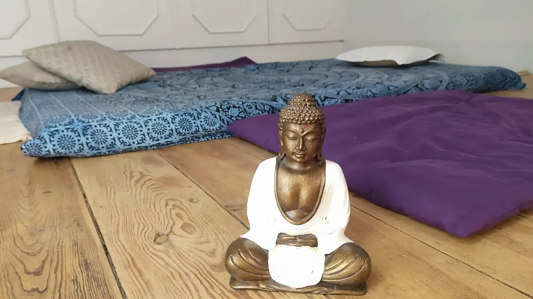 white ceramic buddha figurine on brown wooden table