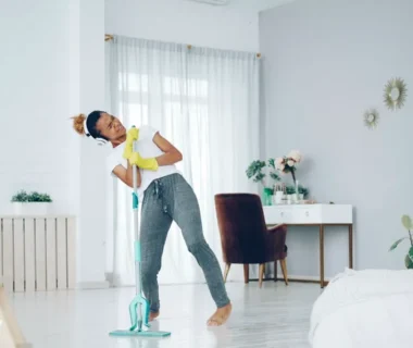 Woman happily mopping the floor while dancing