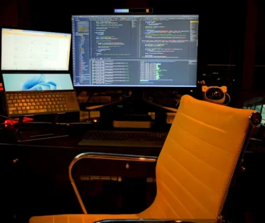 a computer desk with two monitors and a laptop