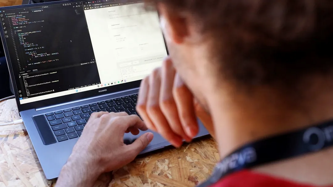 a man sitting at a table using a laptop computer