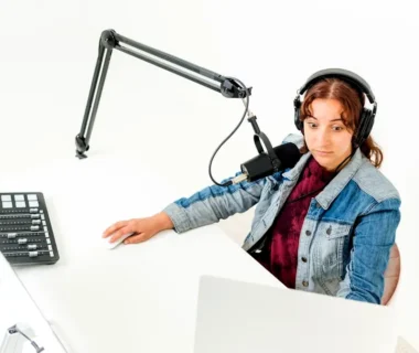 a person wearing headphones and sitting at a desk with a computer
