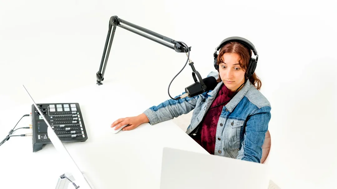 a person wearing headphones and sitting at a desk with a computer