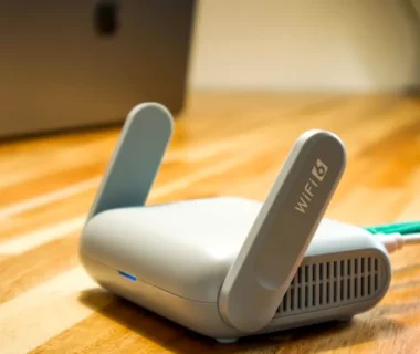 A wireless router sits on a wooden table.