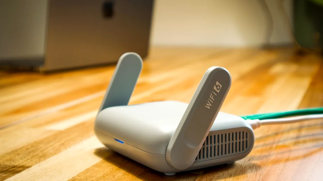 A wireless router sits on a wooden table.