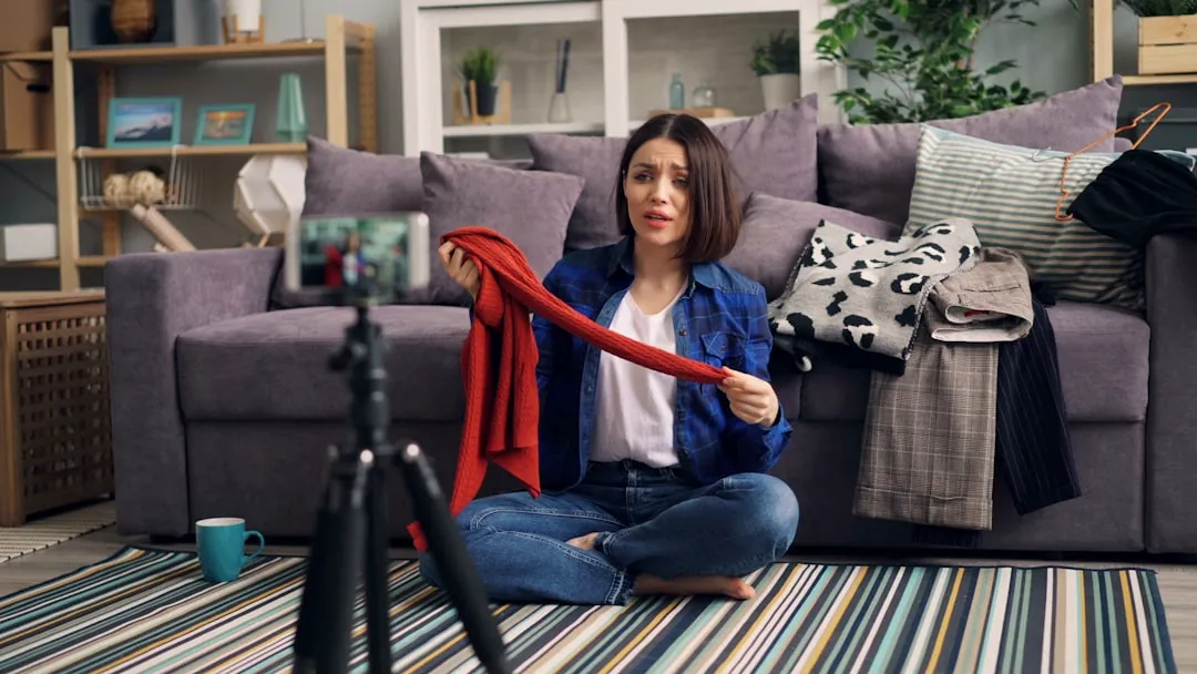 a woman sitting on the floor holding a red scarf