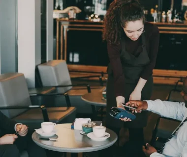 Customer paying with credit card at cafe counter.