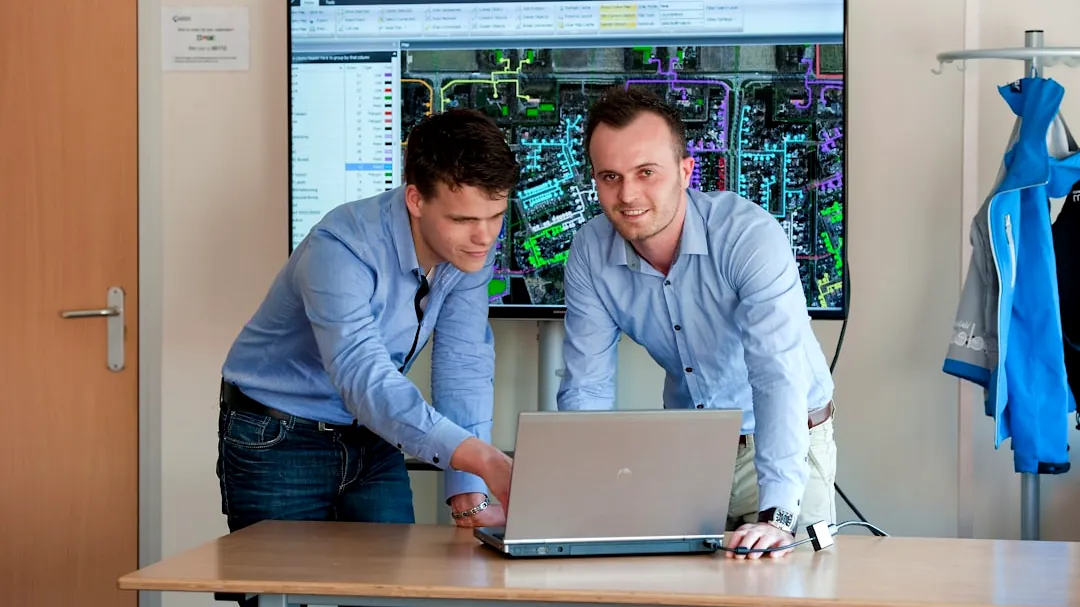 man in blue dress shirt using macbook pro