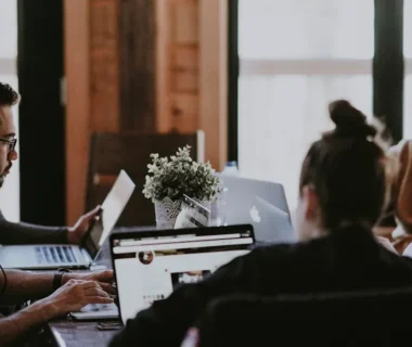 selective focus photography of people sits in front of table inside room