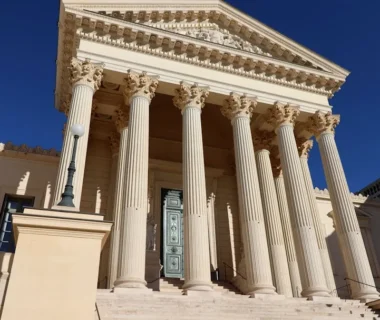 a building with columns and a clock on the front of it