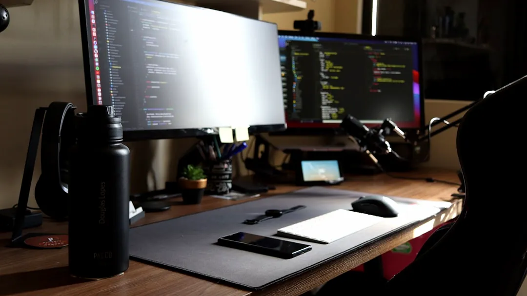 a computer desk with two monitors and a mouse