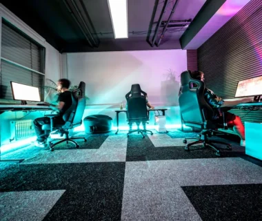 A group of people sitting around a computer desk