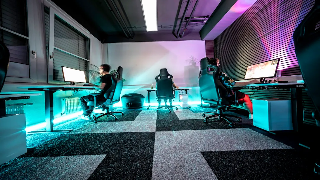 A group of people sitting around a computer desk