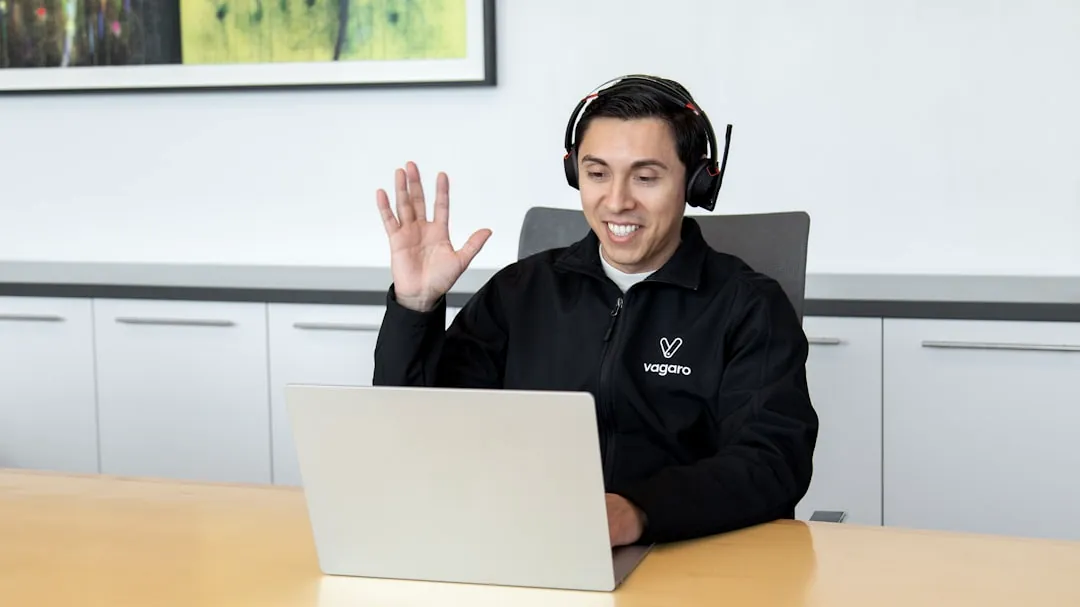 a man wearing headphones sitting in front of a laptop computer