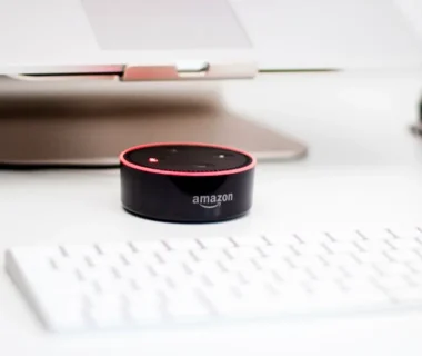 black Amazon Echo Dot speaker beside Apple Magic Mouse