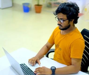 man in yellow crew neck t-shirt using macbook pro