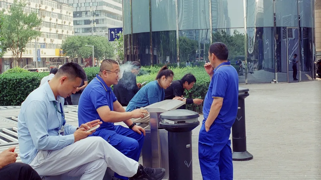 Workers in blue uniforms taking a break outside.