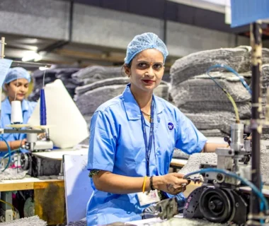 Workers operate machinery in a factory setting.