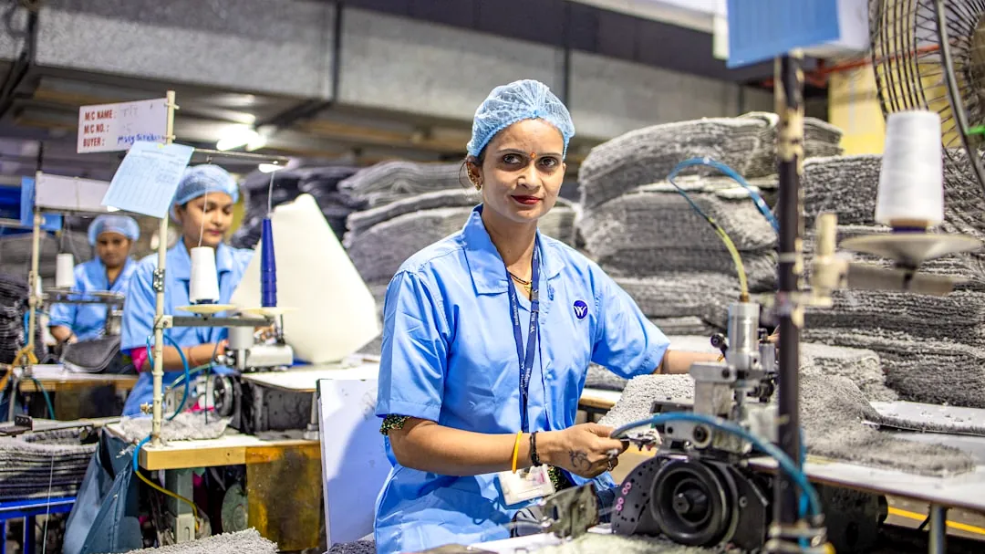 Workers operate machinery in a factory setting.