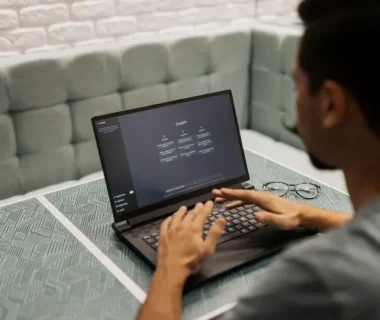 A man working on a laptop in a cozy, modern office space with a focus on technology.